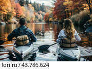 Tourism and sports. Kayakers with oars in their hands are rafting on the river against the background of the autumn landscape. Стоковое AI-изображение, AI-художник Photojuli / Фотобанк Лори
