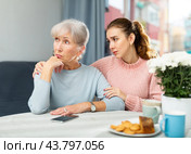 Young woman trying to apologize to offended mother at home. Стоковое фото, фотограф Яков Филимонов / Фотобанк Лори