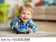 Young child playing with blue toy car on a rug at home, close up view. Generative AI. Стоковое AI-изображение, AI-художник Александра Селина / Фотобанк Лори