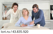 Man and woman help elderly mother make will and fill out document correctly. Стоковое видео, видеограф Яков Филимонов / Фотобанк Лори