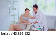 Woman doctor give patient medical documents for review before carrying out cosmetic procedure. Стоковое видео, видеограф Яков Филимонов / Фотобанк Лори