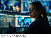 Professional woman working late in hightech control room. Стоковое AI-изображение, AI-художник Иван Рябоконь / Фотобанк Лори