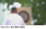 A man is playing darts outside, out of focus. Recreation outdoor sports. Стоковая анимация, аниматор Скрипачев Антон / Фотобанк Лори