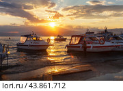 BAIKAL LAKE, OLKHON ISLAND, KHUZHIR VILLAGE, IRKUTSK REGION, RUSSIA - August 04, 2024: A pier for boats and ships against the backdrop of a picturesque sunset. Summer travel and outdoors. Редакционное фото, фотограф Виктория Катьянова / Фотобанк Лори