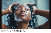 Close up of woman washing hair with soap and rinsing under shower. Стоковое видео, видеограф Данил Руденко / Фотобанк Лори