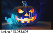 Spooky jack o' lantern with vibrant smoke effects for Halloween. Стоковое видео, видеограф Данил Руденко / Фотобанк Лори