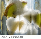 A sunny glass of refreshing lemonade with ice cubes, decorated with slices of fresh lime in a misted glass with droplets. Стоковое фото, фотограф Дмитрий Львович Алферов / Фотобанк Лори