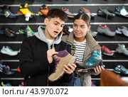Couple examine view several item of winter comfortable trecking shoes. Стоковое фото, фотограф Яков Филимонов / Фотобанк Лори