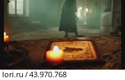 Eerie figure strolling in deserted gothic church with candles. Стоковое AI-видео, аниматор Данил Руденко / Фотобанк Лори