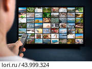 Multimedia streaming concept. person holds remote control. VoD content provider concept. online Television streaming video. Media TV on demand. TV streaming service, remote control in hand. Стоковое фото, фотограф Павел Муравьев / Фотобанк Лори