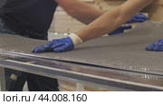 Close-up shot shows the hands of a skilled craftsman as they manipulate a metal mesh frame in a furniture production facility. Стоковое видео, видеограф Strunov David / Фотобанк Лори