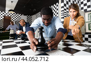 People trying together to find solution of conundrum in quest room. Стоковое фото, фотограф Яков Филимонов / Фотобанк Лори