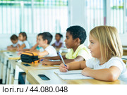 Side view of schoolkids group working on lecture in classroom. Стоковое фото, фотограф Яков Филимонов / Фотобанк Лори