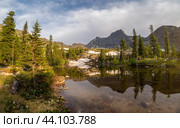 Rocks, crystal clear glacial lake, ancient cedars and pines trees at summer evening. Стоковое фото, фотограф Саблин Станислав / Фотобанк Лори