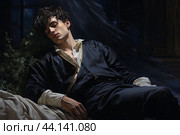 Regal slumber: young man in historical garb asleep. Стоковое AI-изображение, AI-художник Иван Рябоконь / Фотобанк Лори