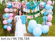 Красивая 41-летняя женщина на вечеринке по выявлению пола ребенка "Гендер пати". «Это мальчик», беременная женщина держит снимок УЗИ и боди для мальчика. беременность после 40. Стоковое фото, фотограф Яна Проничева / Фотобанк Лори