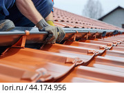 Roofer installing roof gutters on house. Стоковое AI-изображение, AI-художник Иван Рябоконь / Фотобанк Лори
