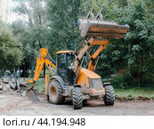 JCB tractor on the repair works in city park. Orange backhoe loader JCB 3CX (2024 год). Редакционное фото, фотограф Константин Григорьев / Фотобанк Лори