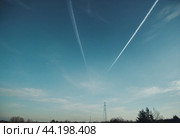 Chemtrail conspiracy theory. Long-lasting condensation trails left in sky by high-flying aircraft are actually chemtrails consisting of chemical or biological agents, sprayed for nefarious purposes. Стоковое AI-изображение, AI-художник Юлия Петровская / Фотобанк Лори