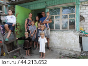 Общая фотография многодетной семьи в деревне на крыльце собственного дома (2024 год). Редакционное фото, фотограф Дмитрий Неумоин / Фотобанк Лори