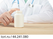Doctor recommends taking medicine, supplement, vitamins, food supplement. Practitioner with bottle of pills. copy space. Стоковое фото, фотограф Павел Муравьев / Фотобанк Лори
