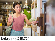 Woman choosing small cabinet in store. Стоковое фото, фотограф Яков Филимонов / Фотобанк Лори