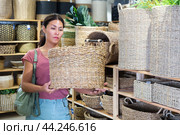 Woman choosing wicker basket in store. Стоковое фото, фотограф Яков Филимонов / Фотобанк Лори