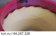 Close Up View of Rotating Dough in a Red Mixing Bowl. Стоковое видео, видеограф Гурьянов Андрей / Фотобанк Лори