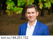 Young business man in a blue suit and white shirt on the background of autumn park. Стоковое фото, фотограф Андрей Аркуша / Фотобанк Лори