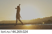 Woman gracefully performing a vibrant latin dance on the beach at sunset. Стоковое видео, видеограф Константин Шишкин / Фотобанк Лори