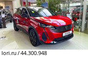 Moscow June 15 2024, A red car with the license plate number 4008 is parked in a showroom. The car is parked in front of a wall and a window. Редакционное фото, фотограф Скрипачев Антон / Фотобанк Лори