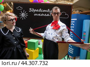 Артисты в одежде школьников на инсталляции пруроченной к началу нового учебного года (1 сентября) в торговом центре ГУМ в городе Москве, Россия (2024 год). Редакционное фото, фотограф Николай Винокуров / Фотобанк Лори