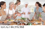 Young woman hold glass of cool white wine in hands and converse with participant at culinary courses. Стоковое видео, видеограф Яков Филимонов / Фотобанк Лори