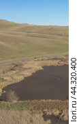 Vertical drone video of flying over a hilly rural landscape with a winding road and fish ponds. Altai Krai. Стоковое видео, видеограф Сергей Пристяжнюк (Serg Zastavkin) / Фотобанк Лори