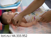 Женина учится пеленать новорожденного ребенка на стенде на тему медицины будущего в Гостином дворе в рамках форума-фестиваля "Территория будущего. Москва 2030" в городе Москве, Россия (2024 год). Редакционное фото, фотограф Николай Винокуров / Фотобанк Лори
