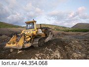 Японский Бульдозер Komatsu D375 в горной местности, боронит верхний слой горного грунта, чтобы затем его сгрести ковшом в отвал (2009 год). Редакционное фото, фотограф Павел Просянов / Фотобанк Лори