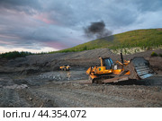 Японский Бульдозер Komatsu D375 в горной местности, боронит верхний слой горного грунта, чтобы затем его сгрести ковшом в отвал (2009 год). Редакционное фото, фотограф Павел Просянов / Фотобанк Лори