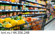 Shopping basket full of grocery products, food and drink , Grocery Shopping: Plan meals and shop with a list, copy space. Стоковое AI-изображение, AI-художник Ирина Ручушкина / Фотобанк Лори