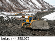 Бульдозеры в горной местности снимает слой за слоем верхние слои грунта, чтобы добраться до золотосодержащего, которые находится на глубине 5-6 метров. Стоковое фото, фотограф Павел Просянов / Фотобанк Лори