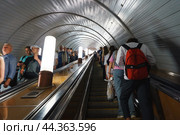 Люди на эскалаторе в московском метро. Переход с Кольцевой на Филевскую линию станции Киевская, г. Москва (2024 год). Редакционное фото, фотограф Viktoriya S. / Фотобанк Лори