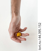 Hand holding yellow die: minimalist concept of chance and decision-making. Стоковое фото, фотограф Lamina Akulova / Фотобанк Лори