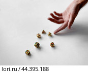 Hand reaching for colorful polyhedral dice on white surface. Стоковое фото, фотограф Lamina Akulova / Фотобанк Лори