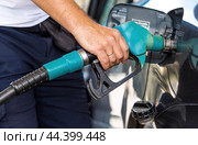 The gas station. A man refuels a car with gasoline. A Russian fuel dispenser in the fuel tank of a car at a gas station. Rising fuel prices around the world. (2024 год). Стоковое фото, фотограф Photojuli / Фотобанк Лори