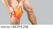 Man with knee pain on gray background. Man leg knee with red dot. Knee injury, sprain, arthritis or meniscus. Man having problems in knee joint. Closeup view. Стоковое фото, фотограф Павел Муравьев / Фотобанк Лори