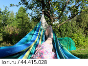 Женские перекрещенные ноги в гамаке в саду летом. Стоковое фото, фотограф Юлия Королева / Фотобанк Лори