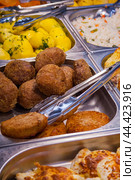 A variety of assortments in the supermarket: cutlets, potatoes on the counter with metal kitchen tongs. Стоковое фото, фотограф Михаил Строгалев / Фотобанк Лори