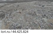 Bulldozer tractor pushes garbage from a mountain in a city dump. Стоковое видео, видеограф Игорь Соловьев / Фотобанк Лори