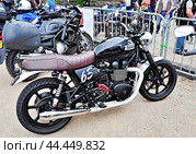 Чёрный британский мотоцикл марки Triumph Bonneville  2015г. выпуска на ретро-выставке небольших транспортных средств (мотоциклов, мопедов и др.) в провинции Франции (2016 г.) Редакционное фото, фотограф Вера Смолянинова / Фотобанк Лори