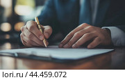 A businessman writes important documents at a wooden desk in an office during afternoon hours with soft natural light. Стоковое AI-изображение, AI-художник Сергей Толмачёв / Фотобанк Лори