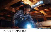 A man inspects an attic space using a flashlight while wearing a hard hat and checking the structure for damage and safety. Стоковое AI-изображение, AI-художник Сергей Толмачёв / Фотобанк Лори
